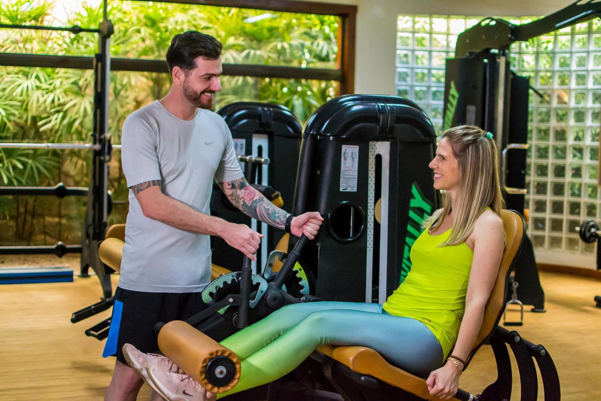 Blue Tree Thermas De Lins Resort Esterno foto Personal trainer assisting a woman on a leg press machine